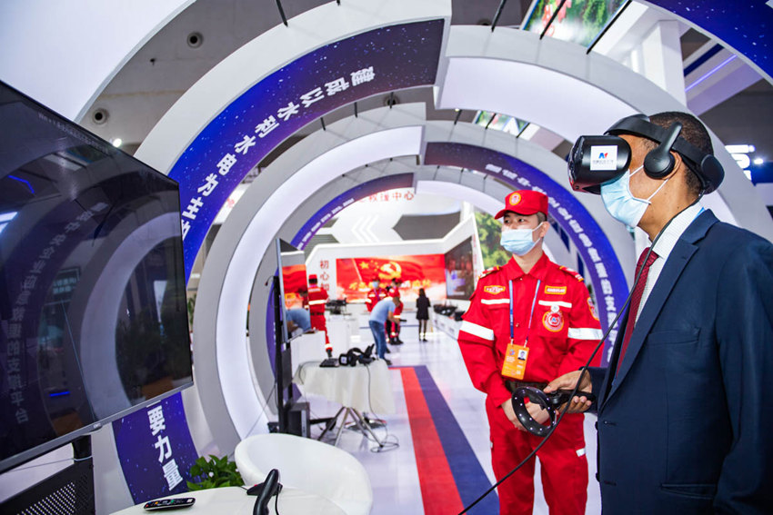 5月21日，重慶國(guó)際博覽中心N3館中國(guó)安能集團(tuán)展廳，外籍客商戴上VR眼鏡、操作手柄，體驗(yàn)防汛險(xiǎn)情、校園地震逃生等虛擬現(xiàn)實(shí)場(chǎng)景，學(xué)習(xí)避險(xiǎn)知識(shí)。鄒樂攝