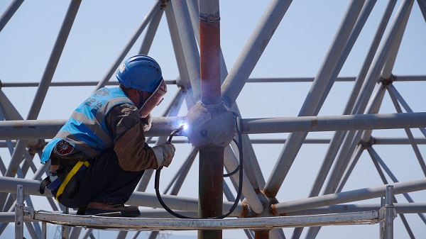 工人正在進(jìn)行鋼架結(jié)構(gòu)施工。唐鑫攝