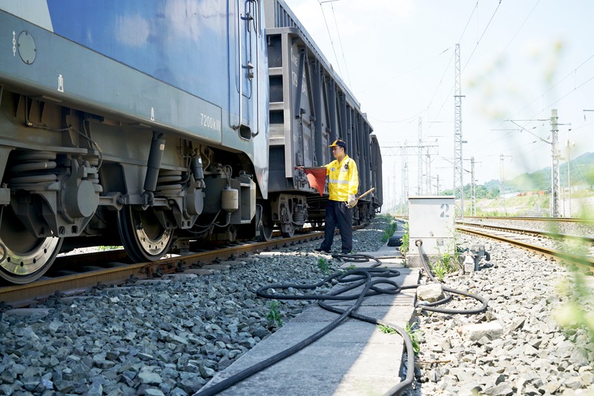 重慶西車輛段貨車檢車員正在插設(shè)紅旗準備作業(yè)。江堯攝