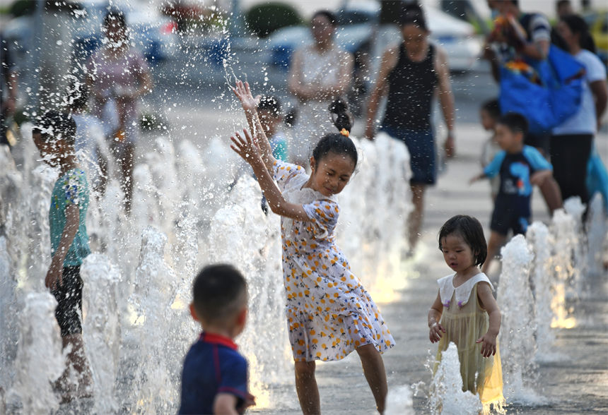 重慶連晴高溫，小朋友在南濱路噴泉下戲水玩耍享受清涼。郭旭攝