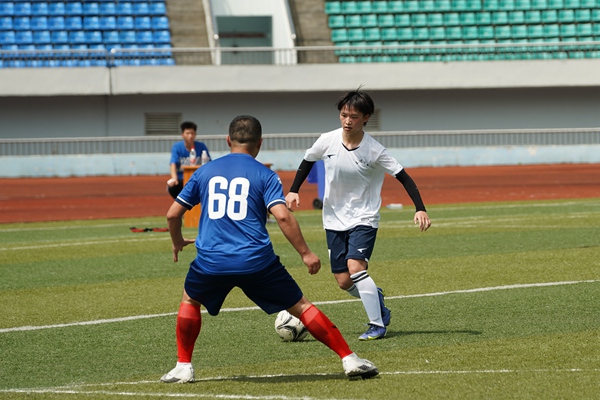 馬慶林（白衣者）帶球突破。石柱縣委宣傳部供圖