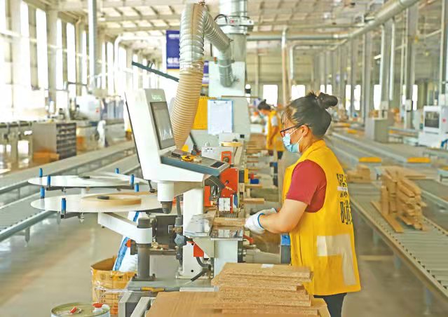 工人使用智能化設(shè)備趕制訂單。前鋒區(qū)融媒體中心供圖