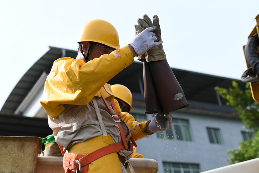 帶電作業(yè)結(jié)束后，工作人員的手套里全是汗水。國(guó)網(wǎng)重慶市電力公司供圖