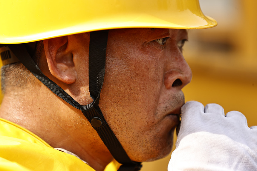 作業(yè)結(jié)束后，工作人員喝下藿香正氣液進(jìn)行消暑。國網(wǎng)重慶市電力公司供圖