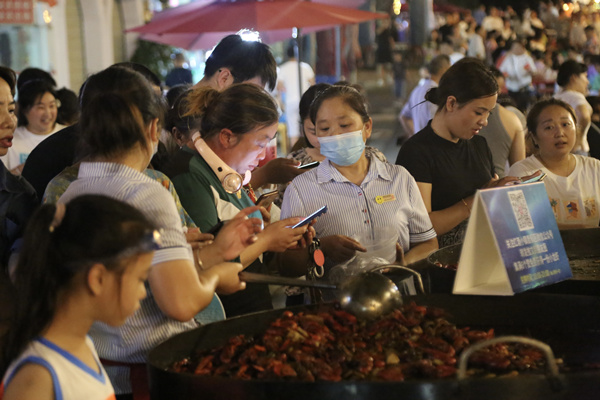 游客品嘗海鮮燒烤。楊孝永攝