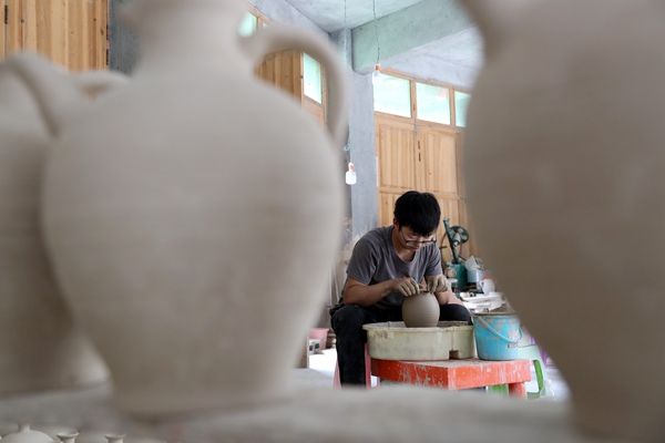 羅達川在給陶坯造型。黔江區(qū)委宣傳部供圖