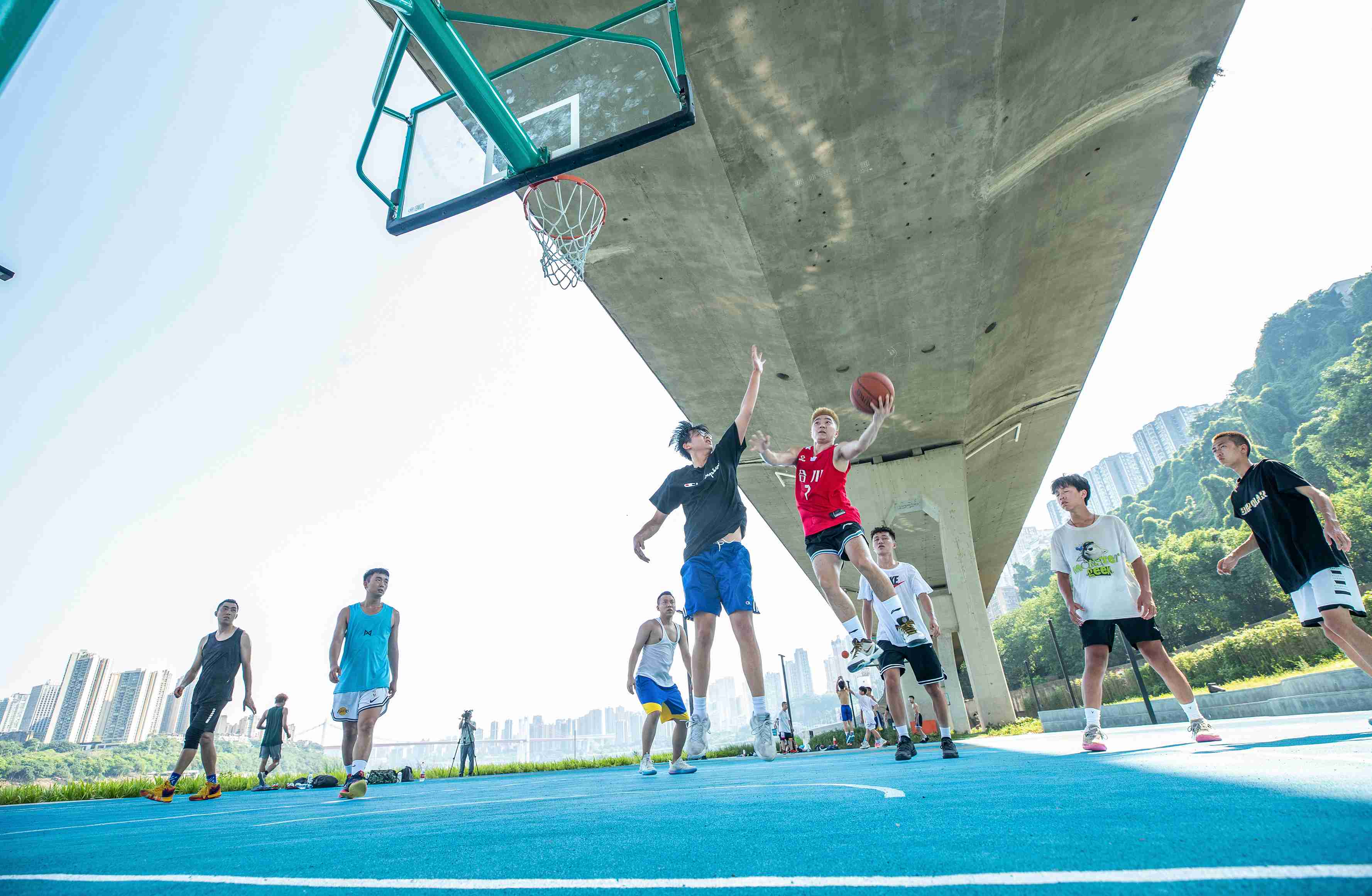 在渝中區(qū)黃沙溪大橋下，市民在長(zhǎng)江邊的籃球場(chǎng)打球。何超攝