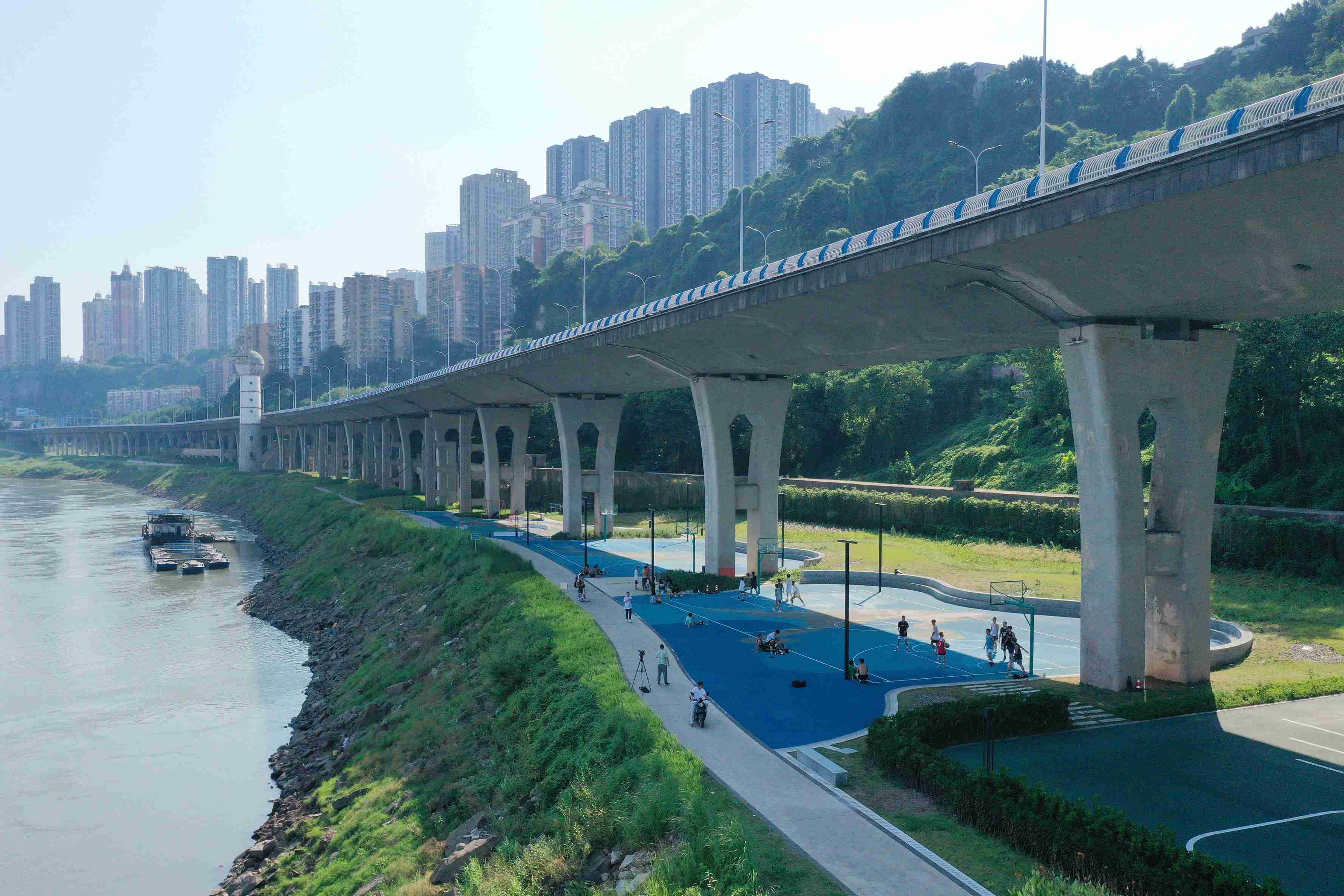 在渝中區(qū)黃沙溪大橋下，市民在長江邊的籃球場打球。何超攝