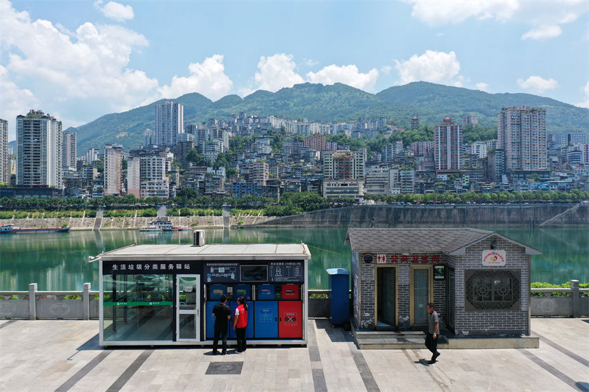 在彭水苗族土家族自治縣南濱路生活垃圾分類服務(wù)驛站，管理員給市民講解垃圾分類知識(shí)。楊敏攝