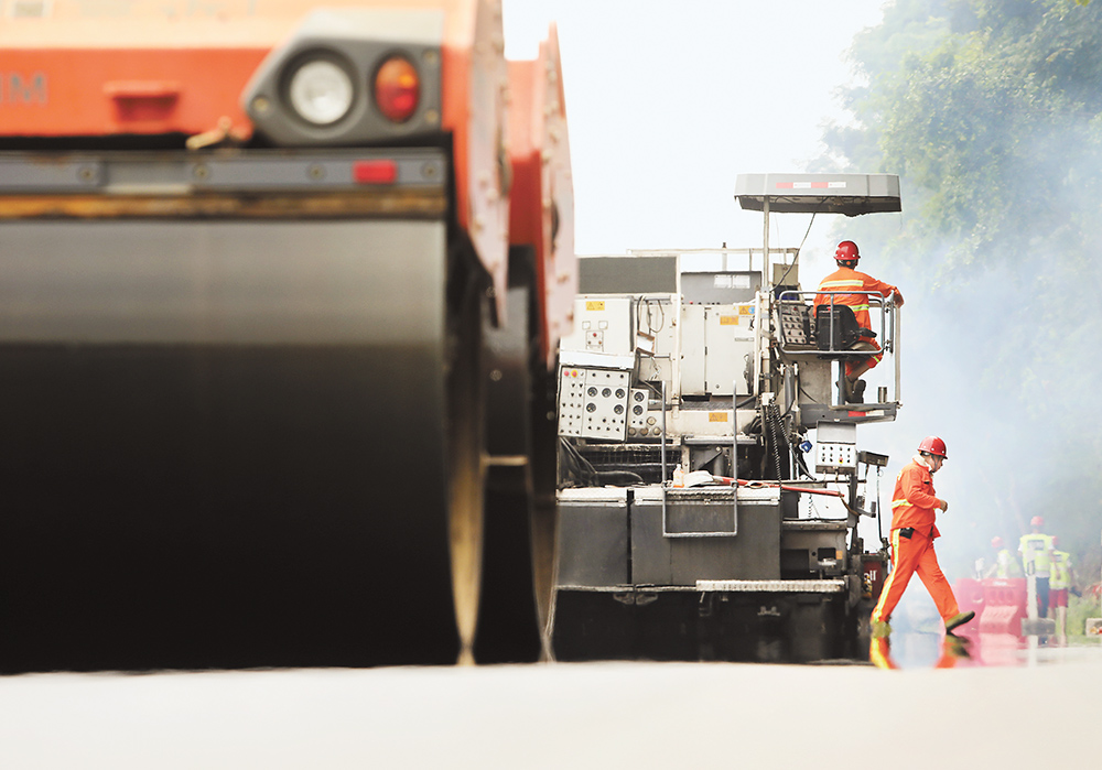 近日，繞城高速青木關(guān)段，重慶高速集團通力公司的養(yǎng)護工人，冒著高溫對路面進行翻新。記者 羅斌 攝視覺重