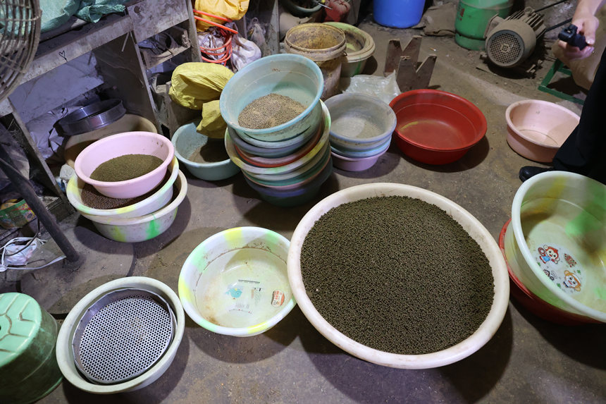 詐騙分子在簡易黑作坊里生產(chǎn)的“藥丸”。兩江新區(qū)警方供圖