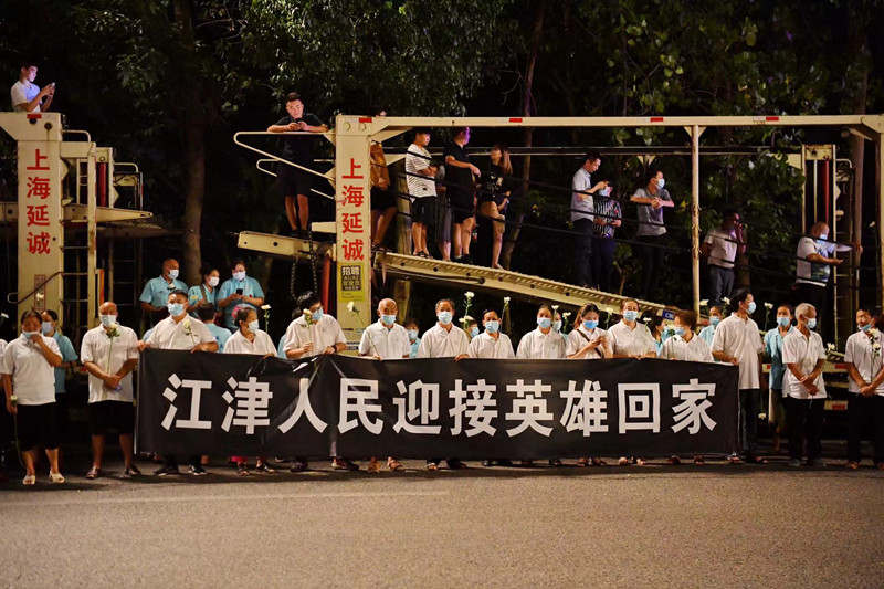當?shù)厝罕娮园l(fā)迎接英雄回家。賀奎攝