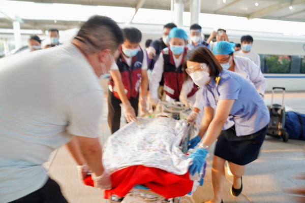 車站工作人員協(xié)助醫(yī)護人員轉(zhuǎn)運燒傷患兒。汪亮攝