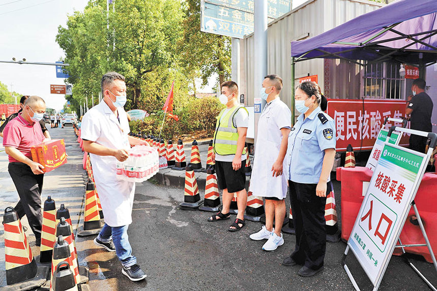 8月16日，成渝高速公路大足郵亭站核酸檢測點(diǎn)，郵亭鎮(zhèn)工作人員送來防暑降溫藥品、飲料等，保護(hù)核酸檢測點(diǎn)工作人員身心健康。通訊員 譚顯全 攝/視覺重慶