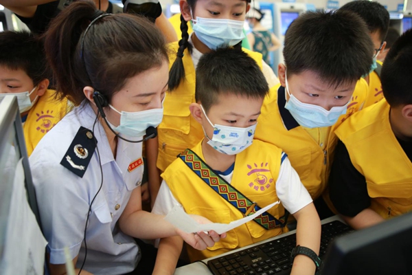 稅務(wù)人員教小朋友查驗(yàn)發(fā)票真假。楊勝男攝