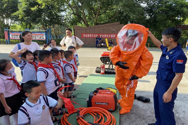 消防員向師生演示消防服的穿戴方法。渝北區(qū)消防救援支隊(duì)供圖