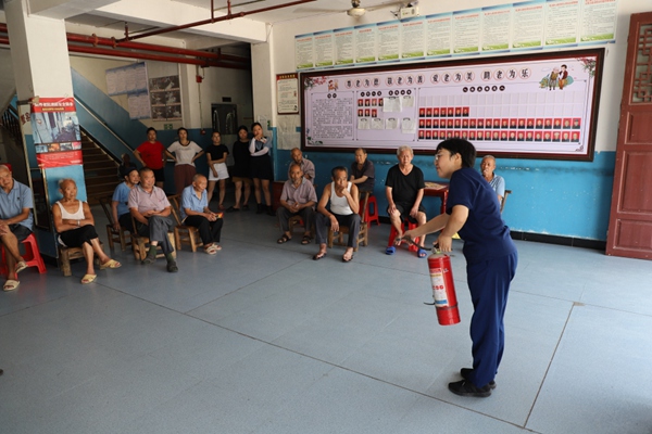 消防宣傳員向群眾講解滅火器的使用方法。秀山縣消防救援大隊供圖