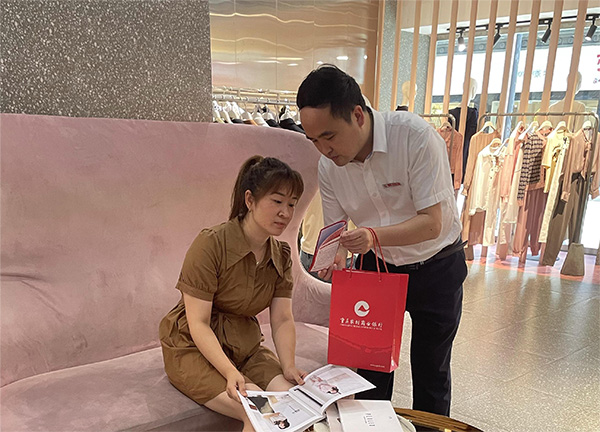 重慶農(nóng)商行武隆支行客戶經(jīng)理向周女士介紹創(chuàng)業(yè)擔(dān)保貸款相關(guān)政策。重慶農(nóng)商行供圖