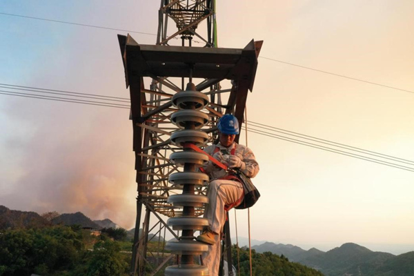 電力工人登塔開(kāi)展搶修作業(yè)。李濤攝