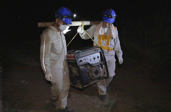 國網(wǎng)北碚供電公司員工在歇馬鎮(zhèn)虎頭山上抬運(yùn)發(fā)電機(jī)。張強(qiáng)攝