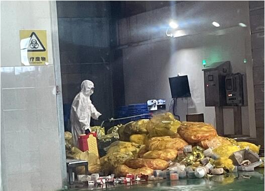 作業(yè)人員對醫(yī)廢垃圾進(jìn)行病毒消殺