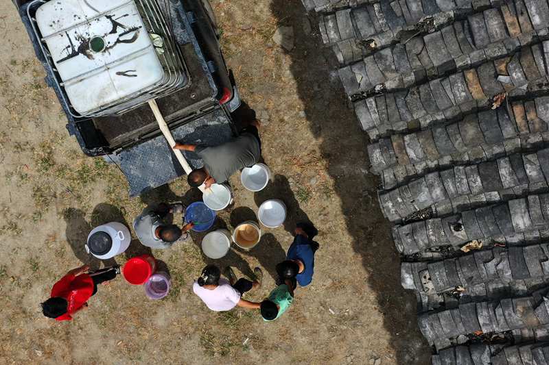 村民在送水車前接水。楊敏攝