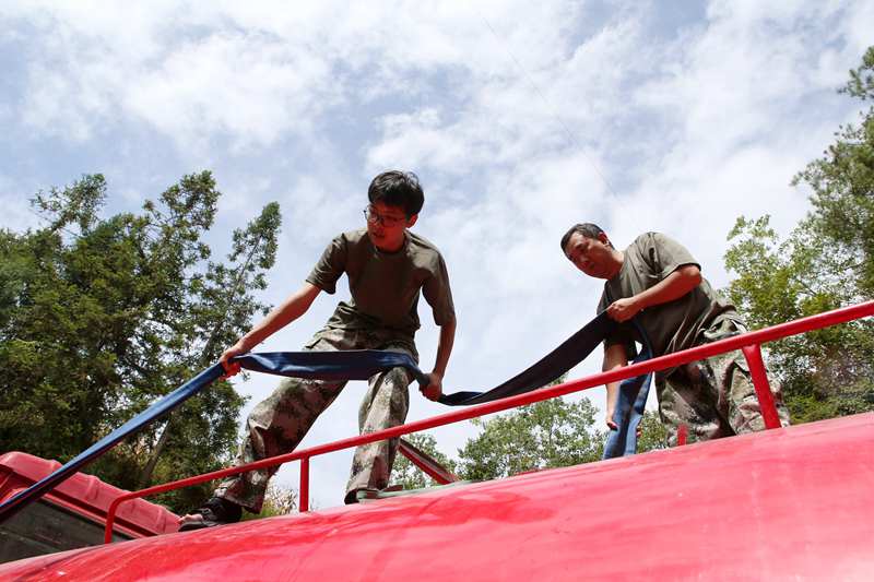 專班人員在新花村新找的水源點給送水車裝水。楊敏攝