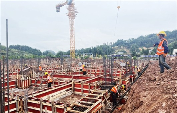 九隆現(xiàn)代中藥有限公司施工現(xiàn)場一派忙碌，工人在綁扎鋼筋、制作安裝模板。李佳遙攝