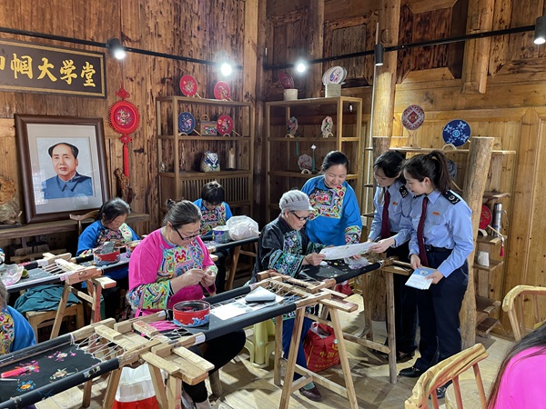 酉陽縣稅務局工作人員走進酉陽縣子月苗族文化傳播有限責任公司，向苗繡職工講解組合式稅費支持政策。 邱冰攝