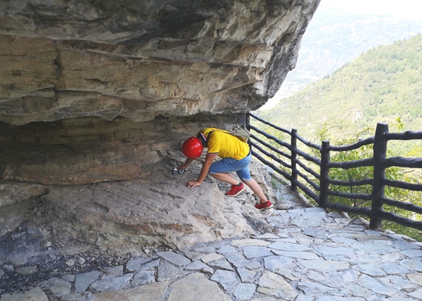 《吊嘴危巖現(xiàn)場調(diào)查》。8月上旬，為做好危巖風(fēng)險管控，重慶地研院地災(zāi)防治技術(shù)人員冒著高溫對奉節(jié)縣瞿塘峽吊嘴危巖用羅盤等儀器進(jìn)行地層巖性、地質(zhì)構(gòu)造等基礎(chǔ)調(diào)查。王琦攝