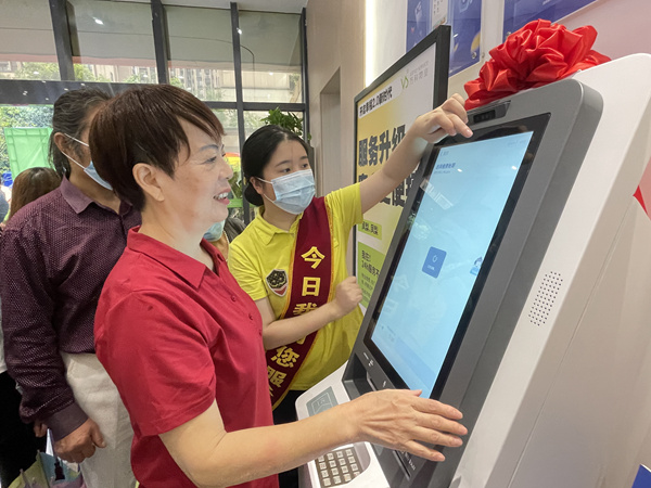 物業(yè)工作人員引導(dǎo)業(yè)主操作“鳳梨一號(hào)”。萬(wàn)科物業(yè)供圖