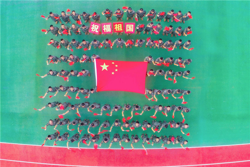 武警官兵與國(guó)旗合影，祝福祖國(guó)。李東攝