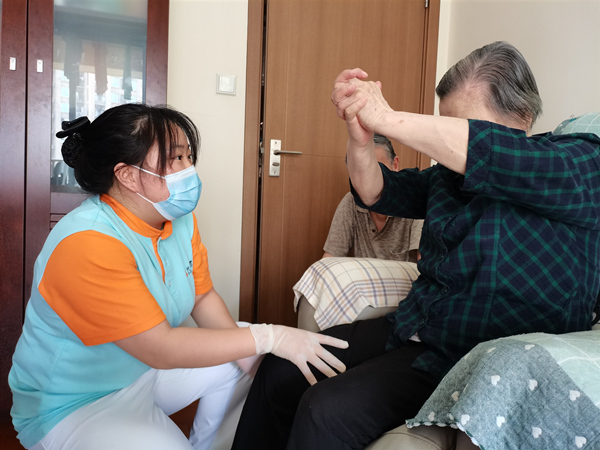 龍山街道社區(qū)養(yǎng)老服務(wù)中心護(hù)士長指導(dǎo)長者肢體康復(fù)訓(xùn)練。龍山街道供圖