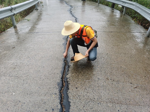 《李家溝滑坡裂縫調(diào)查》。9月上旬，重慶地研院駐守地質(zhì)隊員陳念在雨中巡查奉節(jié)縣李家溝滑坡，調(diào)查滑坡變形裂縫發(fā)展情況。茍青松攝