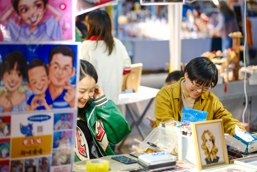 各色攤位一字排開，公園變身熱鬧的集市。郭旭攝