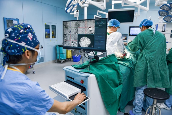 醫(yī)護(hù)人員在機(jī)器人的輔助下進(jìn)行手術(shù)。鄒樂(lè)攝