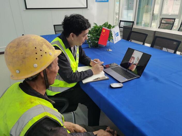 重慶軌道交通15號(hào)線項(xiàng)目幫助使用老年機(jī)的工友視頻聯(lián)系家人。發(fā)展公司供圖