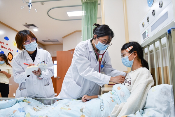 感染科主任醫(yī)師張禎禎（中）檢查住院患者情況。鄒樂攝