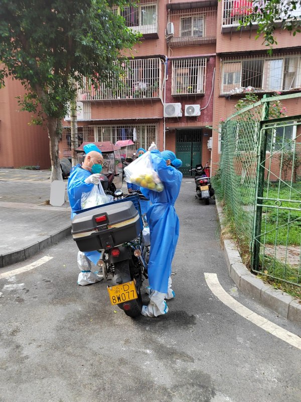 羅興倫（左）和志愿者運(yùn)送物資。龍竹苑社區(qū)供圖