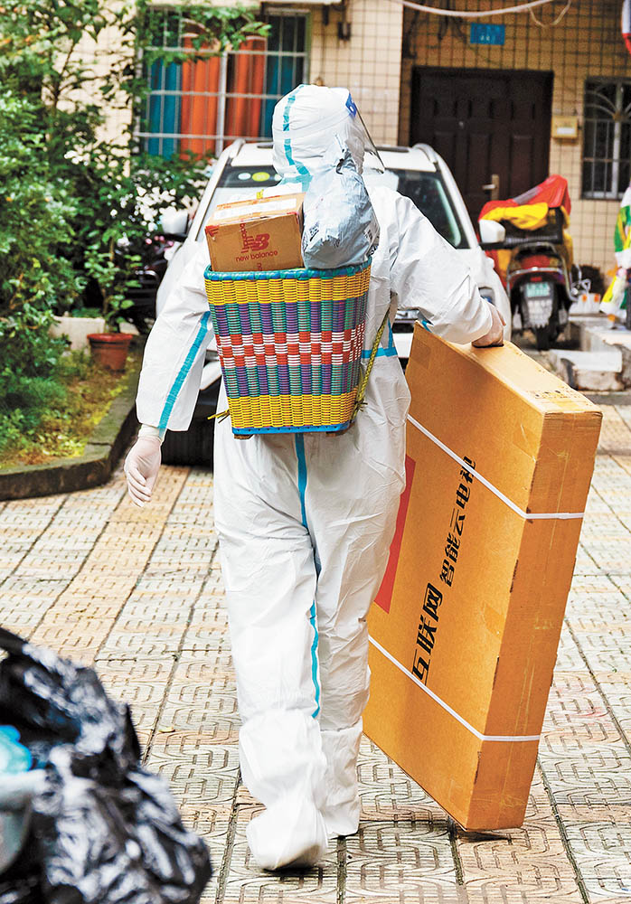 11月14日，萬州區(qū)雙堰塘社區(qū)，山東籍“95后”志愿者王德全為居民送物資。特約攝影 冉孟軍視覺重慶