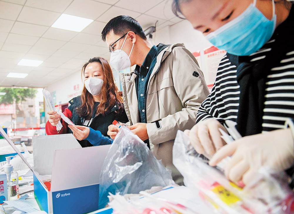 11月14日，渝北區(qū)龍山街道龍山路社區(qū)，“追陽專班”黨員、“95后”志愿者張思源(中)和同事正在準備上門復核核酸采樣的各種物資。記者 崔力 攝 視覺重慶