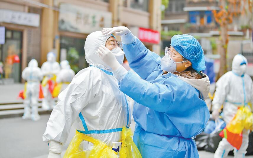 11月14日，九龍坡區(qū)楊家坪街道興勝路社區(qū)，志愿者陳曉宇（右）正在幫助醫(yī)護(hù)人員穿防護(hù)服。記者 鄭宇 通訊員 孫小剛 攝/視覺重慶