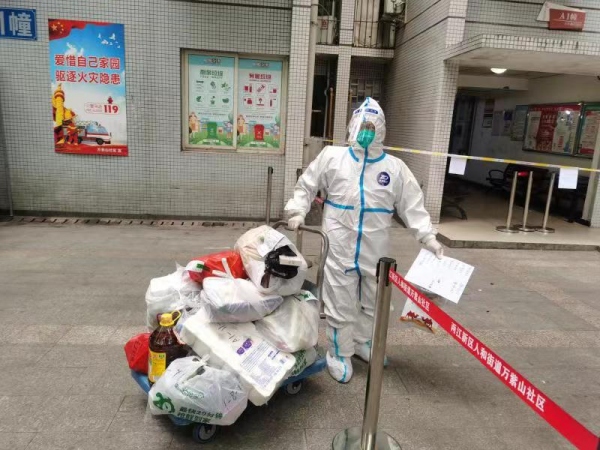 兩江新區(qū)志愿者為居民們搬運(yùn)物質(zhì)。兩江新區(qū)人和街道萬紫山社區(qū)供圖