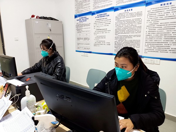 周陽(yáng)（右）和同事一起在辦公室處理信息