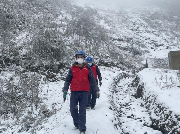 11月30日，國(guó)網(wǎng)城口供電公司員工踩著積雪巡視檢查10千伏廟羅線。王成躍攝