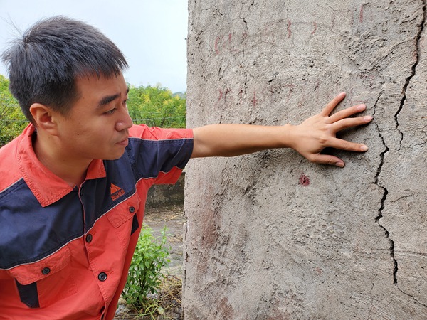 《調查房屋裂縫》。10月17日，南江地質隊駐守地質隊員陳昊在開州區(qū)白鶴街道棕陡坪滑坡調查居民房屋裂縫。彭向東攝
