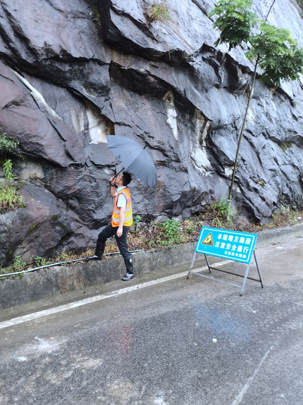 《看·守》。6月23日，208地質(zhì)隊(duì)駐守隊(duì)員曹銳在北碚區(qū)天府鎮(zhèn)雨中巡查公路邊坡。