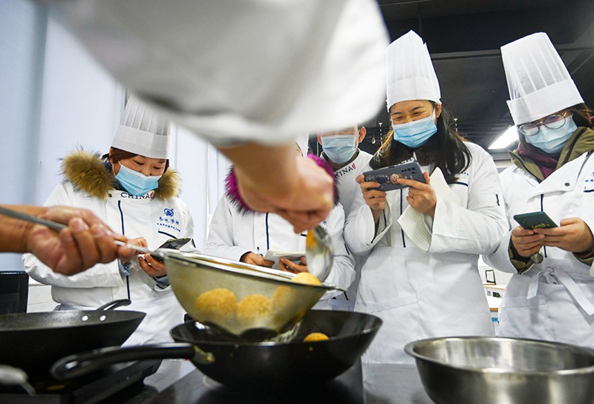 為幫助就業(yè)困難人員掌握一技之長，渝北區(qū)人力社保局開辦各類免費(fèi)技能培訓(xùn)班。圖為學(xué)員們正在老師指導(dǎo)下學(xué)習(xí)制作重慶小吃。(資料圖片）記者 萬難 攝/視覺重慶