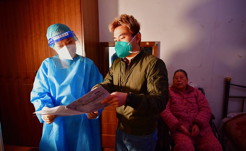 社區(qū)工作人員和醫(yī)護人員在轄區(qū)宣傳疫苗接種。周舸攝