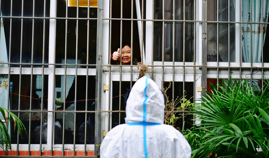 社區(qū)工作人員和醫(yī)護(hù)人員在轄區(qū)宣傳疫苗接種。周舸攝